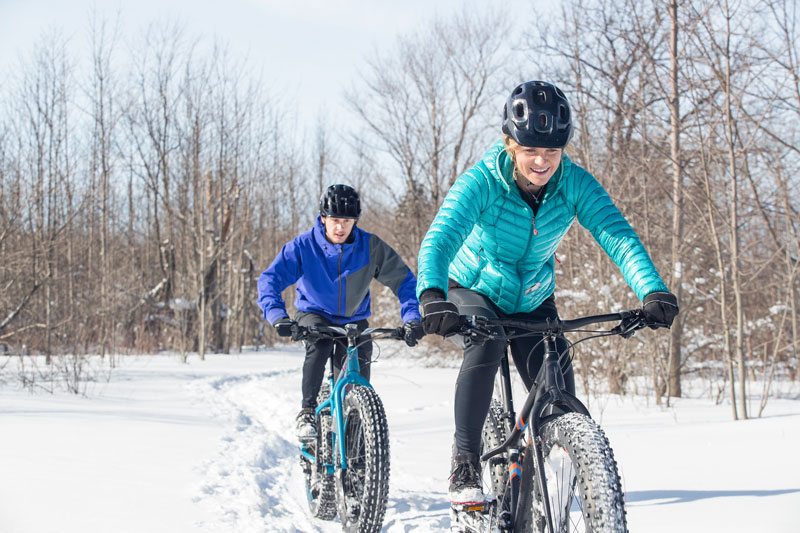 Young couple enjoying fat biking in the winter