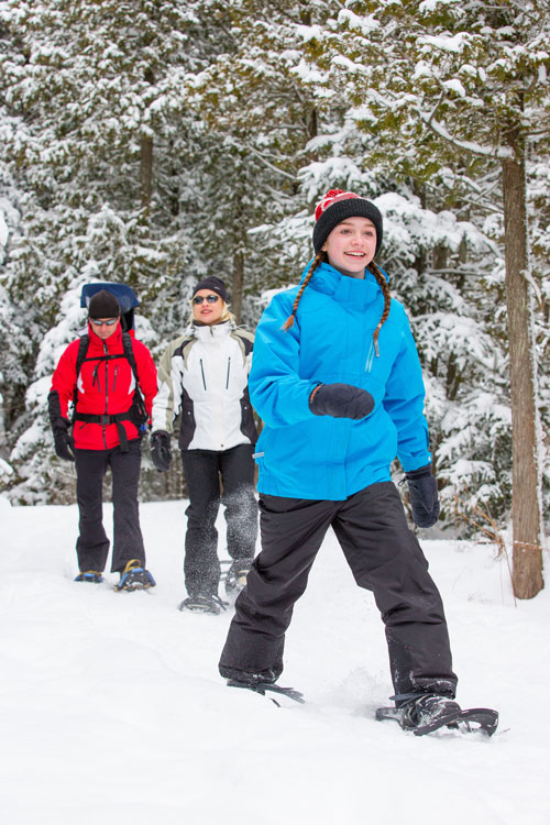 Young child snowshoeing on a trail