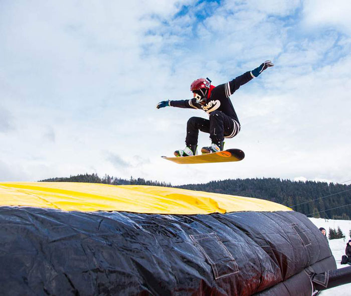 Snowboarder taking a jump into the acrobag